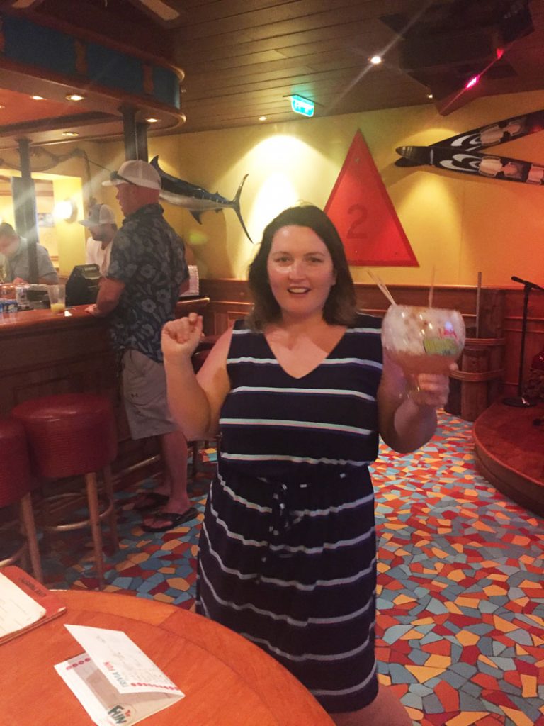 Bethaney dancing to the steel drums and drinking a fishbowl margarita at the Red Frog Pub on Carnival Breeze